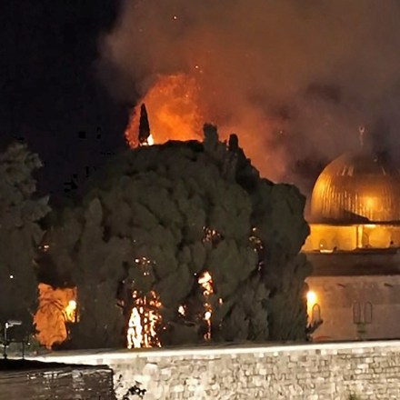 A grab from an AFPTV video shows a tree on fire near the Dome of the Rock mosque in Jerusalem's Al-Aqsa mosque complex on May 10, 2021, following renewed clashes between Palestinians and Israeli police at the scene. (Photo by Claire GOUNON / AFPTV / AFP) (Photo by CLAIRE GOUNON/AFPTV/AFP via Getty Images)