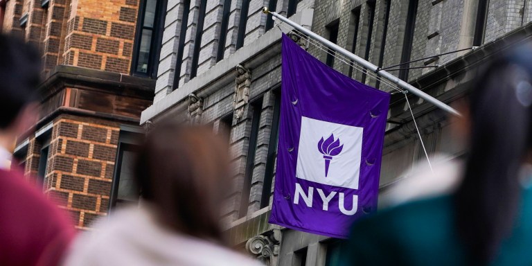 FILE - People wait in line at a COVID-19 testing site near the New York University campus in New York, on Dec. 16, 2021. Ten years after receiving it, NYU publicized on Wednesday, Dec. 14, 2022, a $100 million gift from the hedge fund leader John Paulson, who made a fortune shorting the subprime housing crisis, to support the construction of a now mostly-complete building that will also be named after him. (AP Photo/Seth Wenig, File)