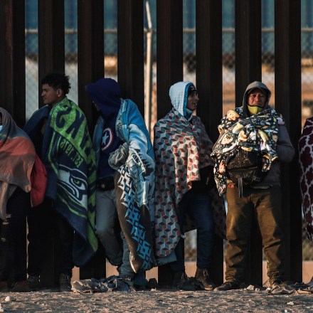 Migrants gather by the border wall in Ciudad Juarez, Mexico, Wednesday, Dec. 21, 2022, on the other side of the border from El Paso, Texas. Migrants gathered along the Mexican side of the Southern border Wednesday as they waited for the U.S. Supreme Court to decide whether and when to lift pandemic-era restrictions that have prevented many from seeking asylum. (AP Photo/Christian Chavez)