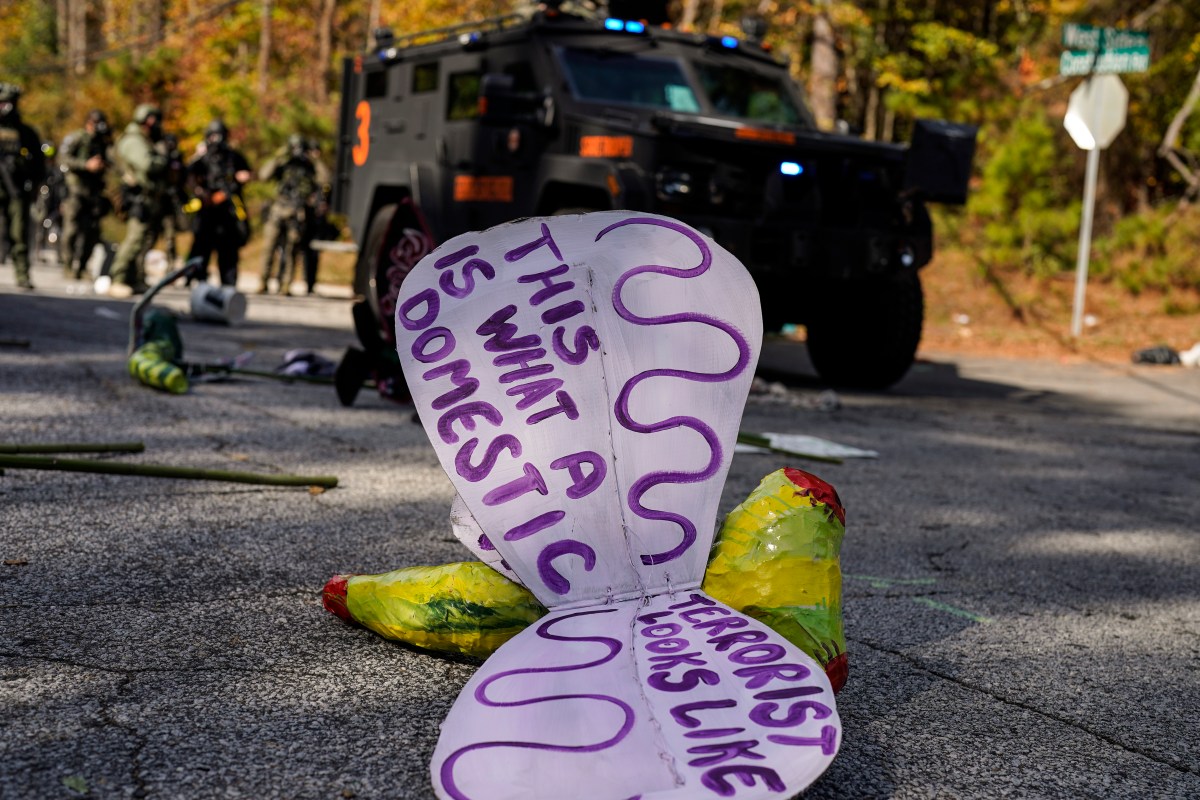 A sign is seen dropped by a protester after gas was spent during a demonstration in opposition to a new police training center, Monday, Nov. 13, 2023, in Atlanta. (AP Photo/Mike Stewart)
