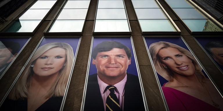 NEW YORK, NY - MARCH 13: Advertisements featuring Fox News personalities, including Tucker Carlson (C), adorn the front of the News Corporation building, March 13, 2019 in New York City. On Wednesday the network's sales executives are hosting an event for advertisers to promote Fox News. Fox News personalities Tucker Carlson and Jeanine Pirro have come under criticism in recent weeks for controversial comments and multiple advertisers have pulled away from their shows. (Photo by Drew Angerer/Getty Images)