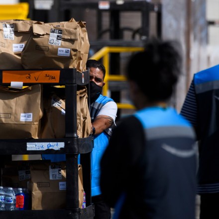 An Amazon.com Inc. delivery driver pushes a cart of groceries to load into a vehicle outside of a distribution facility on February 2, 2021 in Redondo Beach, California. - Jeff Bezos said February 1, 2021, he would give up his role as chief executive of Amazon later this year as the tech and e-commerce giant reported a surge in profit and revenue in the holiday quarter. The announcement came as Amazon reported a blowout holiday quarter with profits more than doubling to $7.2 billion and revenue jumping 44 percent to $125.6 billion. (Photo by Patrick T. FALLON / AFP) (Photo by PATRICK T. FALLON/AFP via Getty Images)