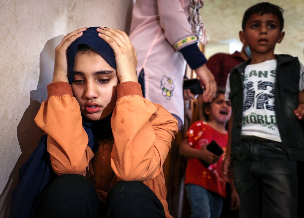 TOPSHOT - Relatives of Palestinian Hussien Hamad, 11, mourn during his funeral in Beit Hanoun in the northern Gaza Strip on May 11, 2021. - Israel and Hamas exchanged heavy fire, with 22 Palestinians killed in Gaza, in a dramatic escalation between the bitter rivals sparked by unrest at Jerusalem's flashpoint Al-Aqsa Mosque compound. Nine children were among those killed in the blockaded Gaza Strip that is controlled by the Islamist movement and 106 people there were wounded, local health authorities said. (Photo by MAHMUD HAMS / AFP) (Photo by MAHMUD HAMS/AFP via Getty Images)