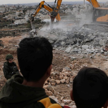 Bulldozers demolish a Palestinian house, which the Israelis claim to be built without permit, in south of the West Bank city of Hebron, Dec. 28, 2021. (Photo by Mamoun Wazwaz/Xinhua via Getty Images)
