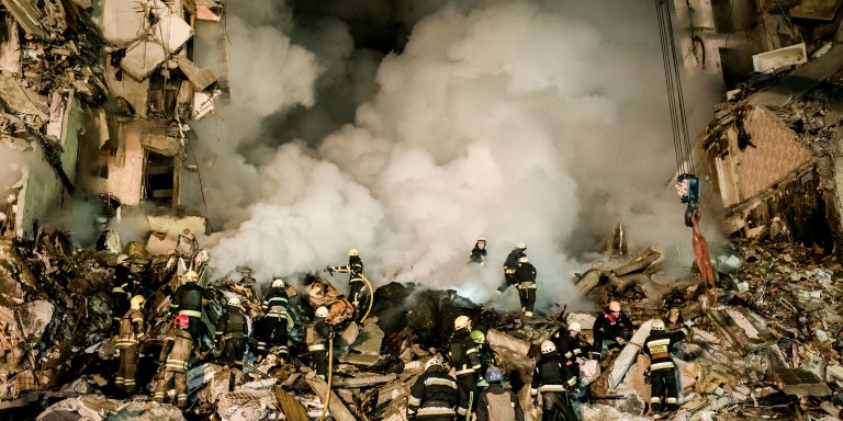 Rescuers work to free victims from the rubble of a residential apartment complex that was hit by Russian forces in Dnipro, Ukraine, on January 14, 2023. Several people were killed and more than 25 were injured, including children. The attack marked the most significant strike on the central Ukrainian city since the war began. Dnipro had until now served as a safe haven for thousands of displaced people from other regions. (Photo by Wojciech Grzedzinski/For The Washington Post via Getty Images)