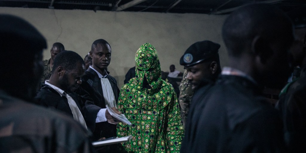 A masked witness leaves the military court in Goma, eastern Democratic Republic of Congo, during the trial against six soldiers accused of crimes against humanity and violating orders, on September 15, 2023. Six soldiers, including two officers of the elite Republican Guard, faced a military tribunal over the killing of nearly 50 people in a crackdown on an anti-UN protest in Goma. Congolese soldiers had on August 30, 2023 stopped a religious sect from holding a demonstration against United Nations peacekeepers in the city. (Photo by ALEXIS HUGUET / AFP) (Photo by ALEXIS HUGUET/AFP via Getty Images)