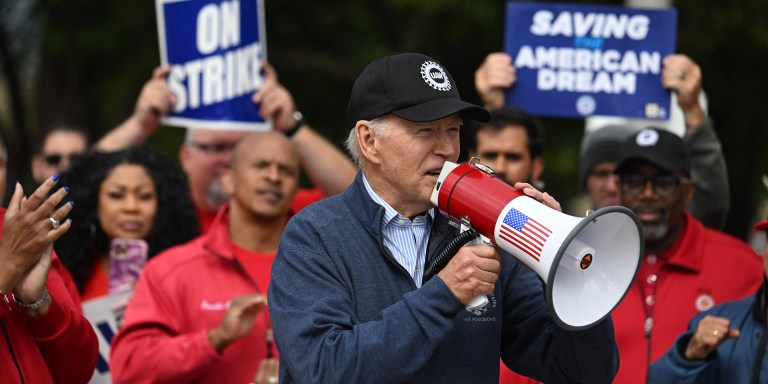 TOPSHOT - US President Joe Biden addresses striking members of the United Auto Workers (UAW) union at a picket line outside a General Motors Service Parts Operations plant in Belleville, Michigan, on September 26, 2023. Some 5,600 members of the UAW walked out of 38 US parts and distribution centers at General Motors and Stellantis at noon September 22, 2023, adding to last week's dramatic worker walkout. According to the White House, Biden is the first sitting president to join a picket line. (Photo by Jim WATSON / AFP) (Photo by JIM WATSON/AFP via Getty Images)