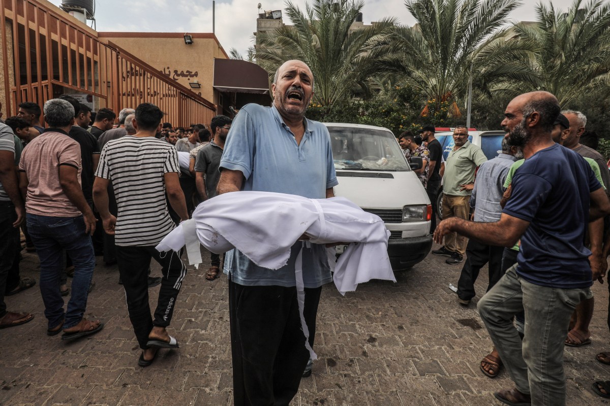11 October 2023, Palestinian Territories, Khan Yunis: A man reacts while carrying the body of a Palestinian child, killed in an Israeli air strike, in front of a morgue ahead of his burial. Photo: Abed Rahim Khatib/dpa (Photo by Abed Rahim Khatib/picture alliance via Getty Images)