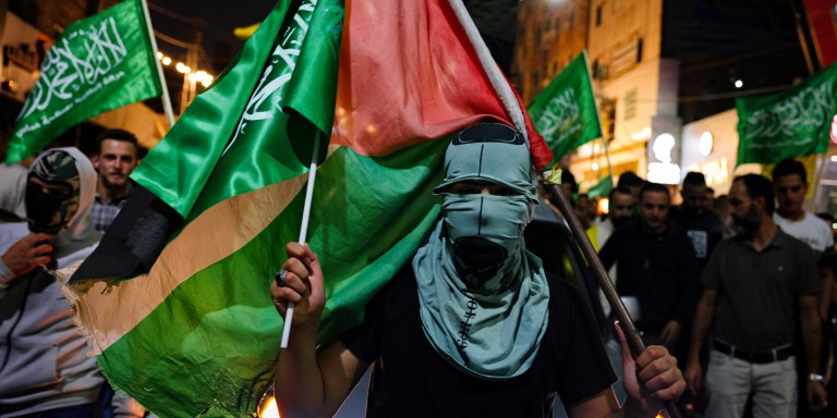 Supporters of the Fatah and Hamas movments lift group and Palestinian flags as they march in Hebron city in the occupied West Bank on October 11, 2023, to protest the Israeli bombardment of the Gaza Strip. Israel kept up its bombardment of Hamas targets in the Gaza Strip on October 11, as Prime Minister Benjamin Netanyahu and a political rival announced an emergency government for the duration of the conflict that has killed thousands. (Photo by HAZEM BADER / AFP) (Photo by HAZEM BADER/AFP via Getty Images)