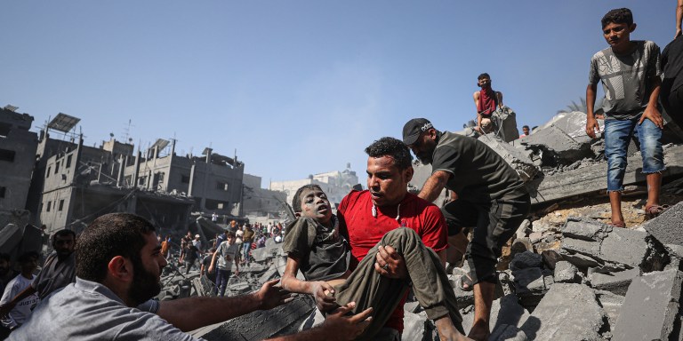 KHAN YUNIS, GAZA - OCTOBER 26: A victim is being carried by the civilians after pulled from under the rubble in the city of Khan Yunis, Gaza where some buildings collapsed or heavily damaged in Israeli airstrikes on October 26, 2023. (Photo by Mustafa Hassona/Anadolu via Getty Images)