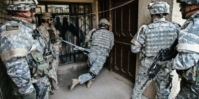 BAGHDAD, Iraq:  US soldiers from Bravo Company 1-87 Infantry 10th Mountain Division 1st Brigade Combat Team break down the door of a civilian Iraqi home in order to search the building during a patrol in western Baghdad, 31 October, 2005.  Seven US soldiers were killed in separate bomb explosions in Iraq, the military said today. Four died when their patrol struck an improvised explosive device in the Yusufiyah district, southwest of Baghdad.  AFP PHOTO/DAVID FURST  (Photo credit should read DAVID FURST/AFP via Getty Images)