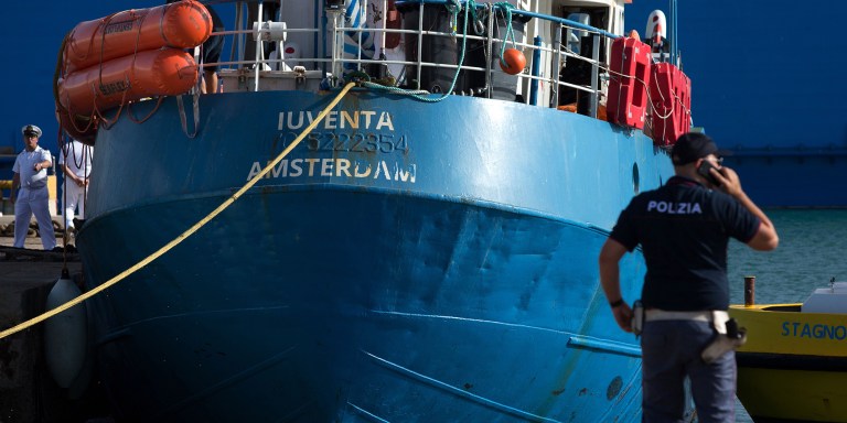 An Italian police officer stands by the Iuventa rescue ship, run by the German NGO Jugend Rettet, in Trapani, Italy, on Aug. 4, 2017.