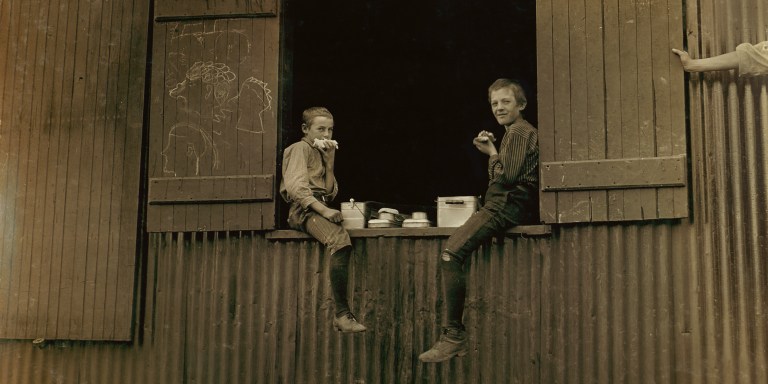 Two Young Boys eating Lunch, Economy Glass Works, Morgantown, West Virginia, USA, Lewis Hine for National Child Labor Committee, October 1908. (Photo by: GHI/Universal Images Group via Getty Images)