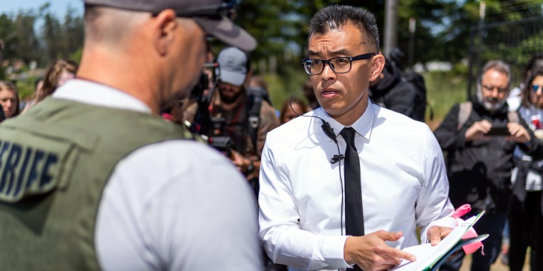 Attorney, activist, and Direct Action Everywhere founder Wayne Hsiung talks to a sheriff at Reichardt Duck Farm in Sonoma County, Calif., in June 2019. (edited)
